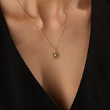 Model wearing a 14k gold vermeil beaded coin necklace featuring a gleaming pendant with a star-set cubic zirconia and ornate beaded border for a touch of everyday luxury.
