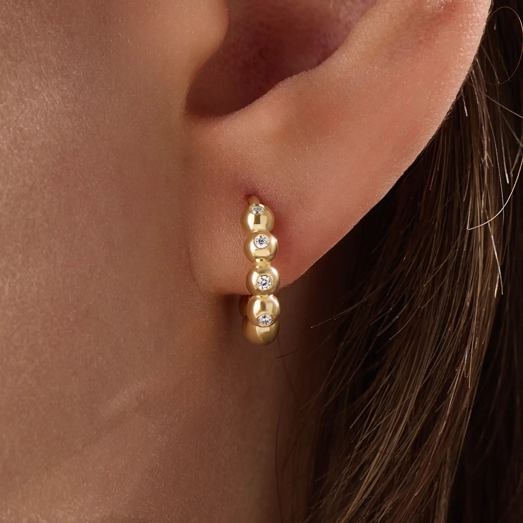 Model wearing 14k gold vermeil beaded hoop earrings showcasing the radiant beaded design and subtle shimmer, perfect for everyday elegance or evening wear.

