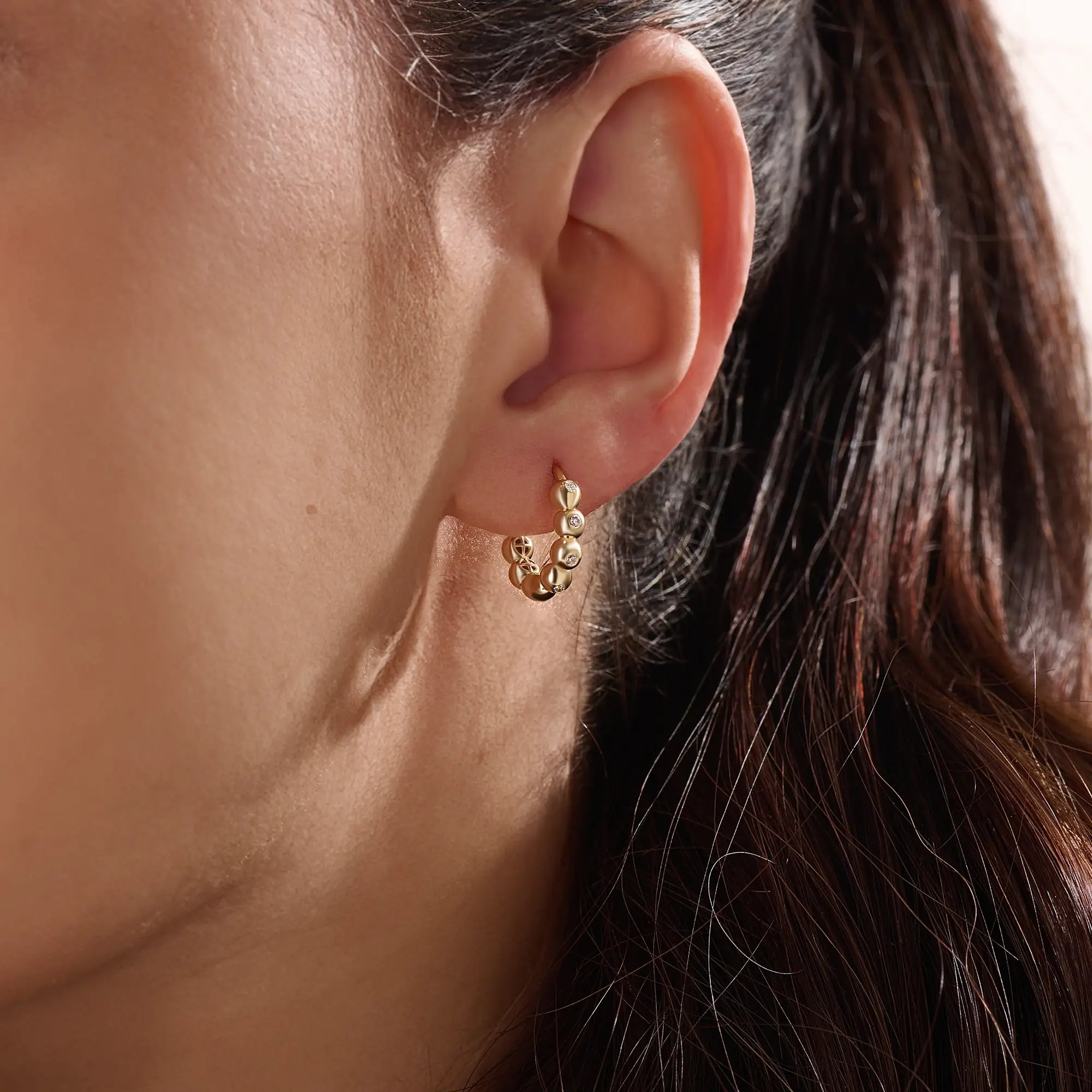 Model wearing 14k gold vermeil beaded hoop earrings showcasing the radiant beaded design and subtle shimmer, perfect for everyday elegance or evening wear.
