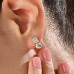 Model wearing 14k gold vermeil toi et moi stud earrings featuring a duo of emerald and round-cut stones, exuding modern sophistication with a classic touch.
