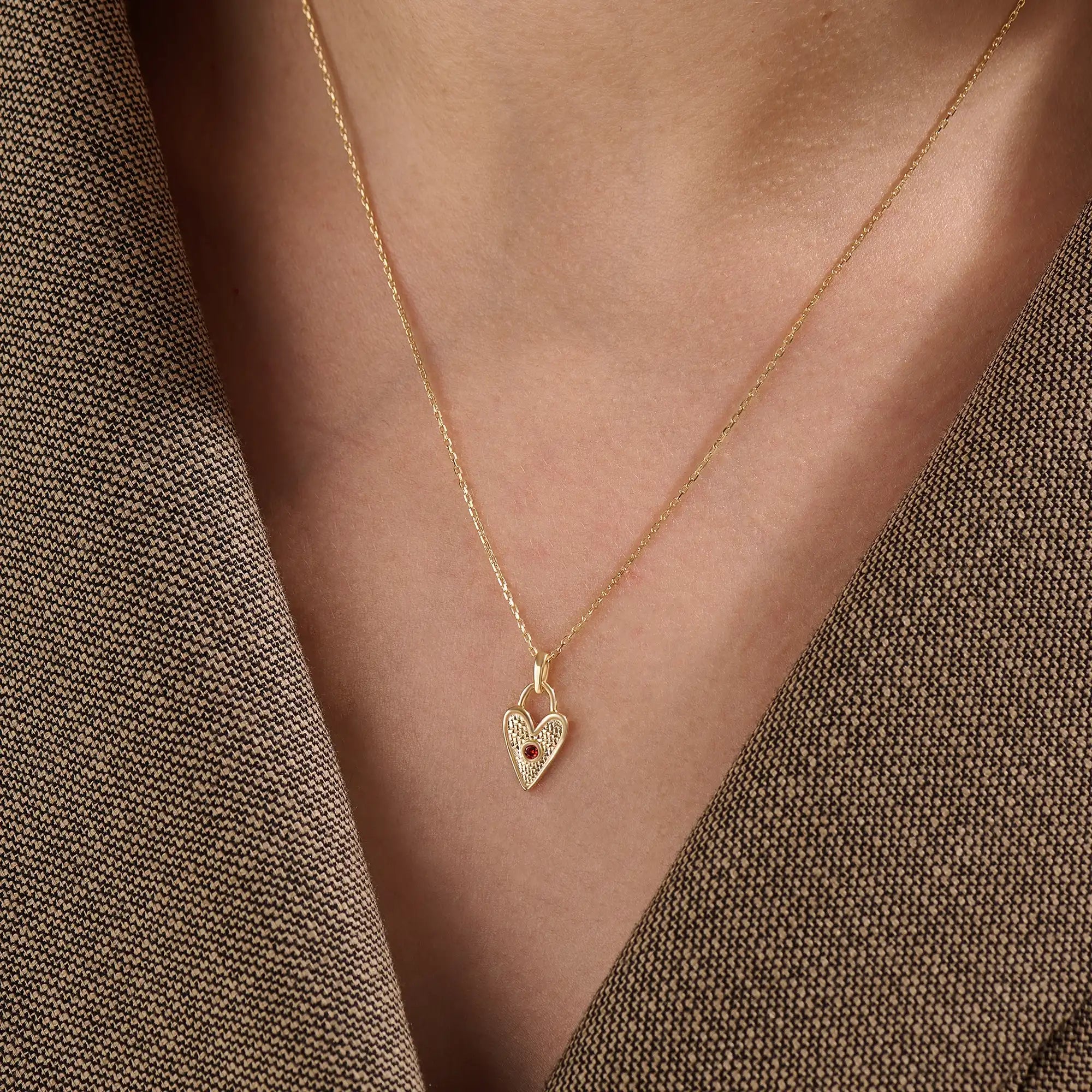 Model wearing a 14k gold vermeil birthstone heart necklace featuring a unique heart lock pendant with a colored gemstone accent for a sentimental, stylish statement.

