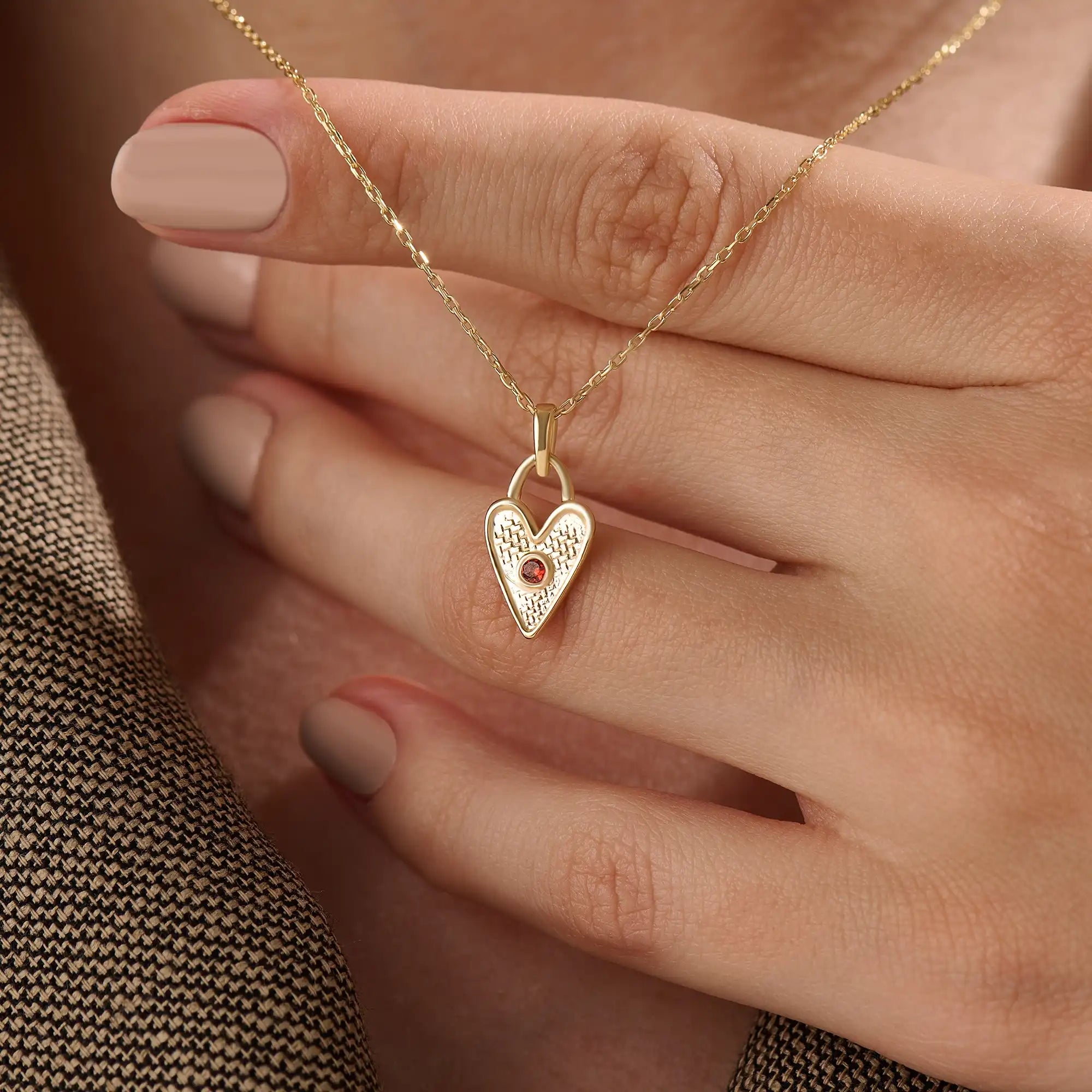 Model wearing a 14k gold vermeil birthstone heart necklace featuring a unique heart lock pendant with a colored gemstone accent for a sentimental, stylish statement.
