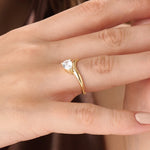 Model wearing a 14k gold vermeil curve pear ring with a cubic zirconia gemstone, accentuating its sleek silhouette and sophisticated brilliance.
