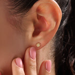 Model wearing 14k gold vermeil daisy stud earrings featuring a floral silhouette and shimmering cubic zirconia center, perfect for an elegant, nature-inspired look.
