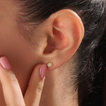 Model wearing 14k gold vermeil daisy stud earrings featuring a floral silhouette and shimmering cubic zirconia center, perfect for an elegant, nature-inspired look.
