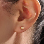 Model wearing 14k gold vermeil daisy stud earrings featuring a floral silhouette and shimmering cubic zirconia center, perfect for an elegant, nature-inspired look.
