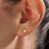 Model wearing 14k gold vermeil daisy stud earrings featuring a floral silhouette and shimmering cubic zirconia center, perfect for an elegant, nature-inspired look.
