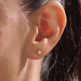 Model wearing 14k gold vermeil daisy stud earrings featuring a floral silhouette and shimmering cubic zirconia center, perfect for an elegant, nature-inspired look.
