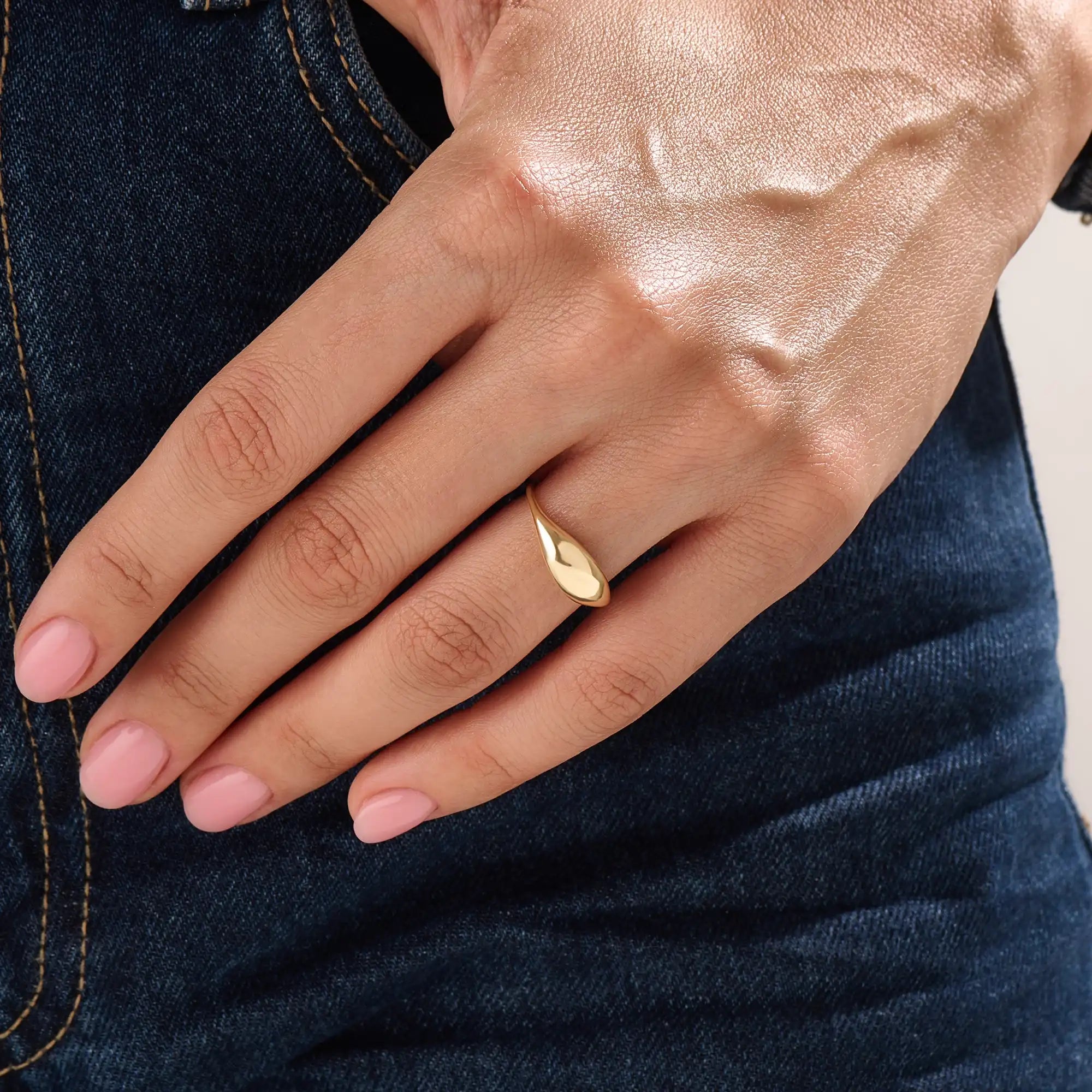 Model wearing a 14k gold vermeil dome signet ring, showcasing its elegant domed design and luxurious golden luster for a chic everyday look.

