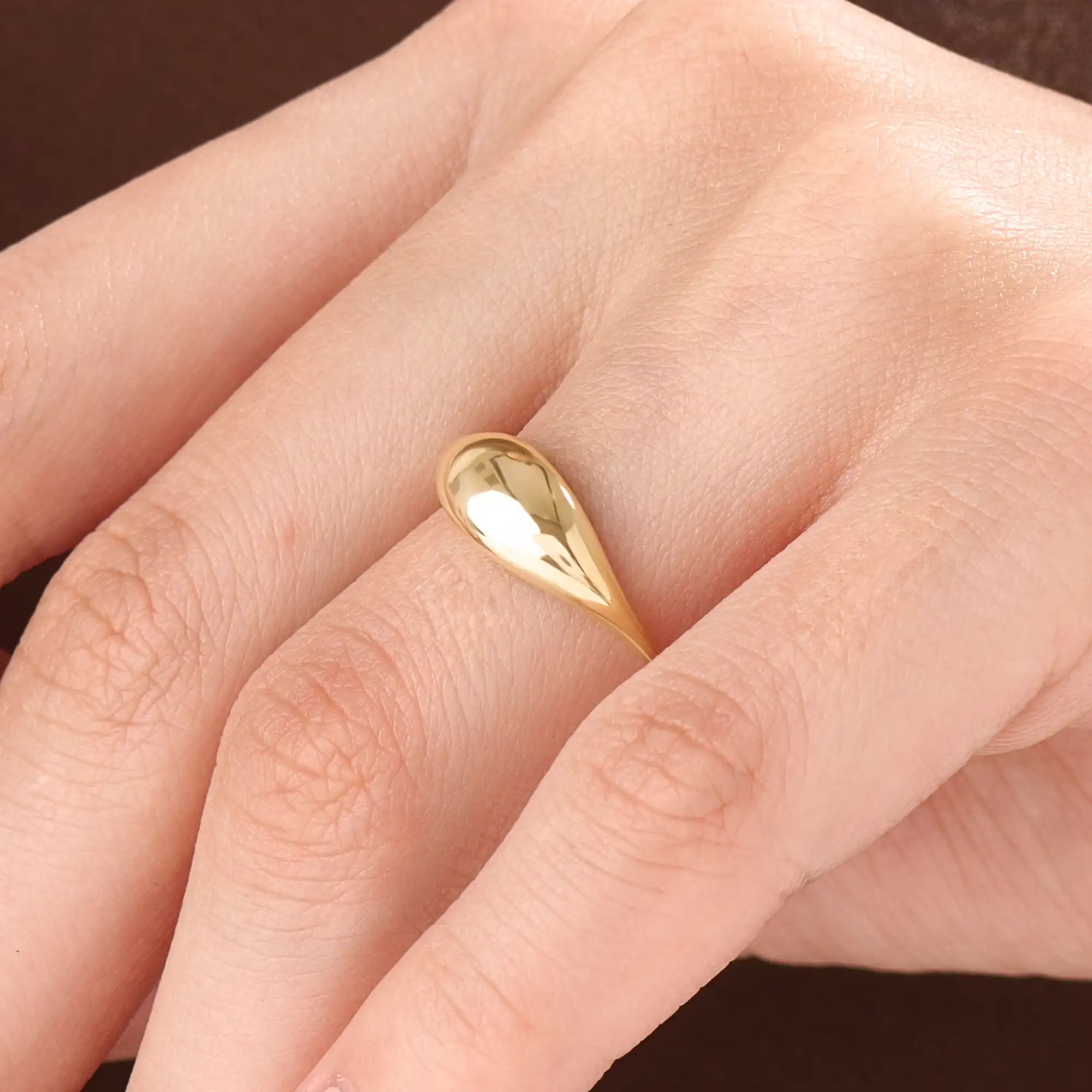 Model wearing a 14k gold vermeil dome signet ring, showcasing its elegant domed design and luxurious golden luster for a chic everyday look.
