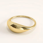 Side view of 14k gold vermeil dome signet ring highlighting its smooth curvature and bold domed profile with a reflective polished finish.
