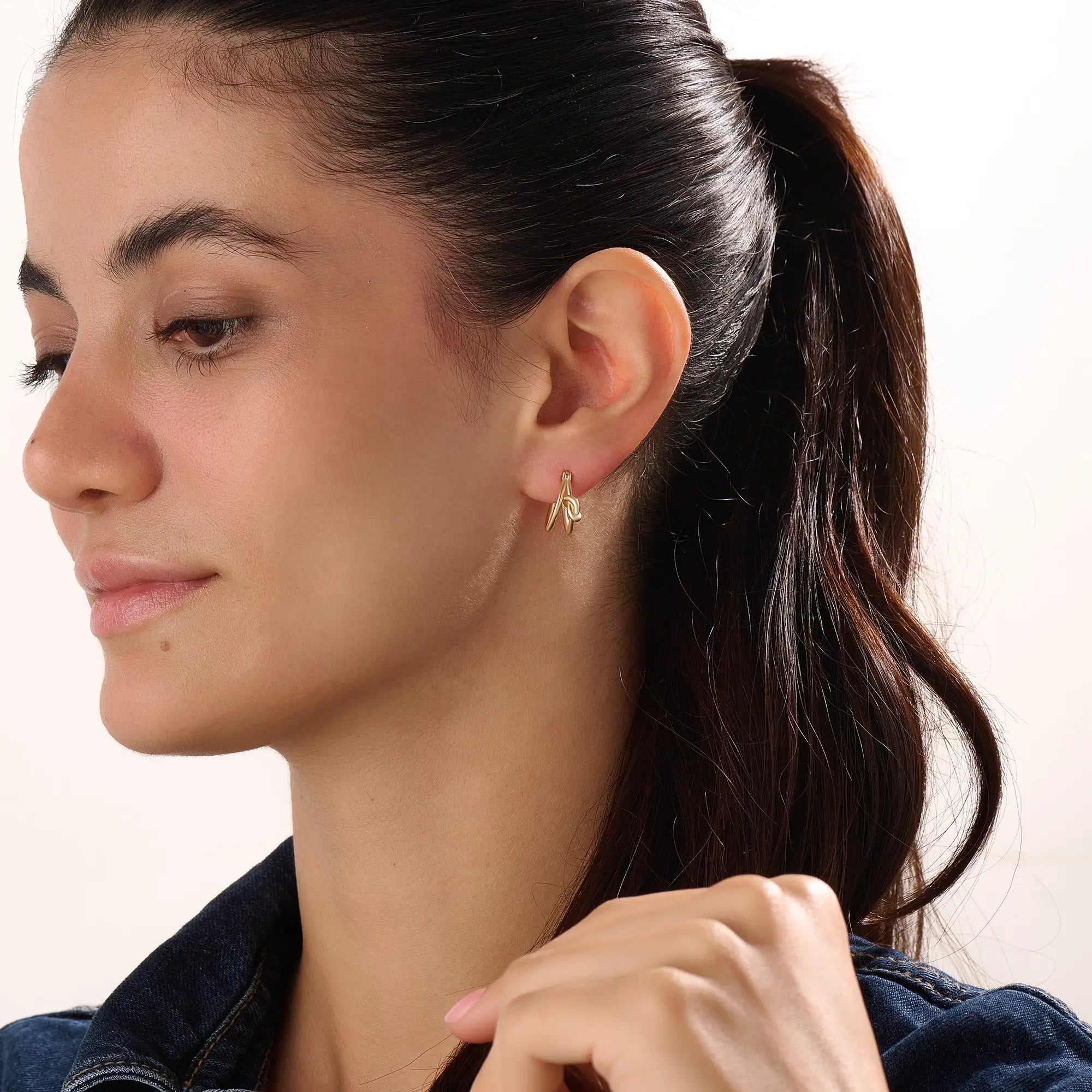 Model wearing 14k gold vermeil knot hoop earrings highlighting their chic, contemporary shape and radiant shine — perfect for both casual and elegant styles.
