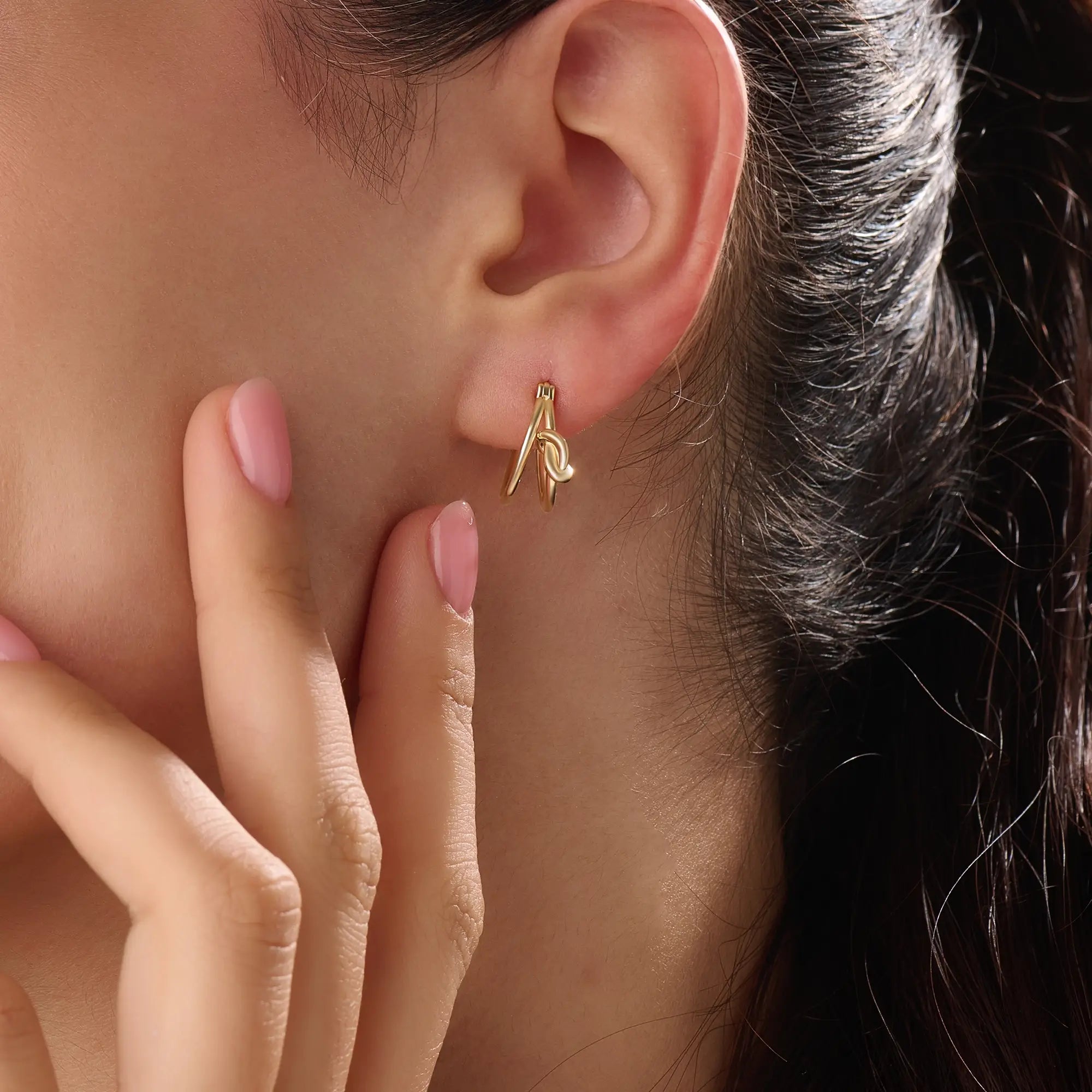 Model wearing 14k gold vermeil knot hoop earrings highlighting their chic, contemporary shape and radiant shine — perfect for both casual and elegant styles.

