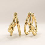 Side view of 14k gold vermeil knot hoop earrings showcasing the sculptural knot accent and seamless hinge closure for a comfortable and secure fit.
