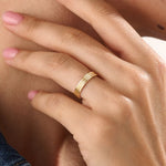 Model wearing a 14k gold vermeil line band ring, showcasing its elegant triple-line design and lustrous golden finish for a timeless minimalist look.
