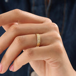 Model wearing a 14k gold vermeil line band ring, showcasing its elegant triple-line design and lustrous golden finish for a timeless minimalist look.
