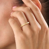 Model wearing a 14k gold vermeil lined band ring, emphasizing its modern ribbed texture and elegant golden tone for a timeless everyday look.
