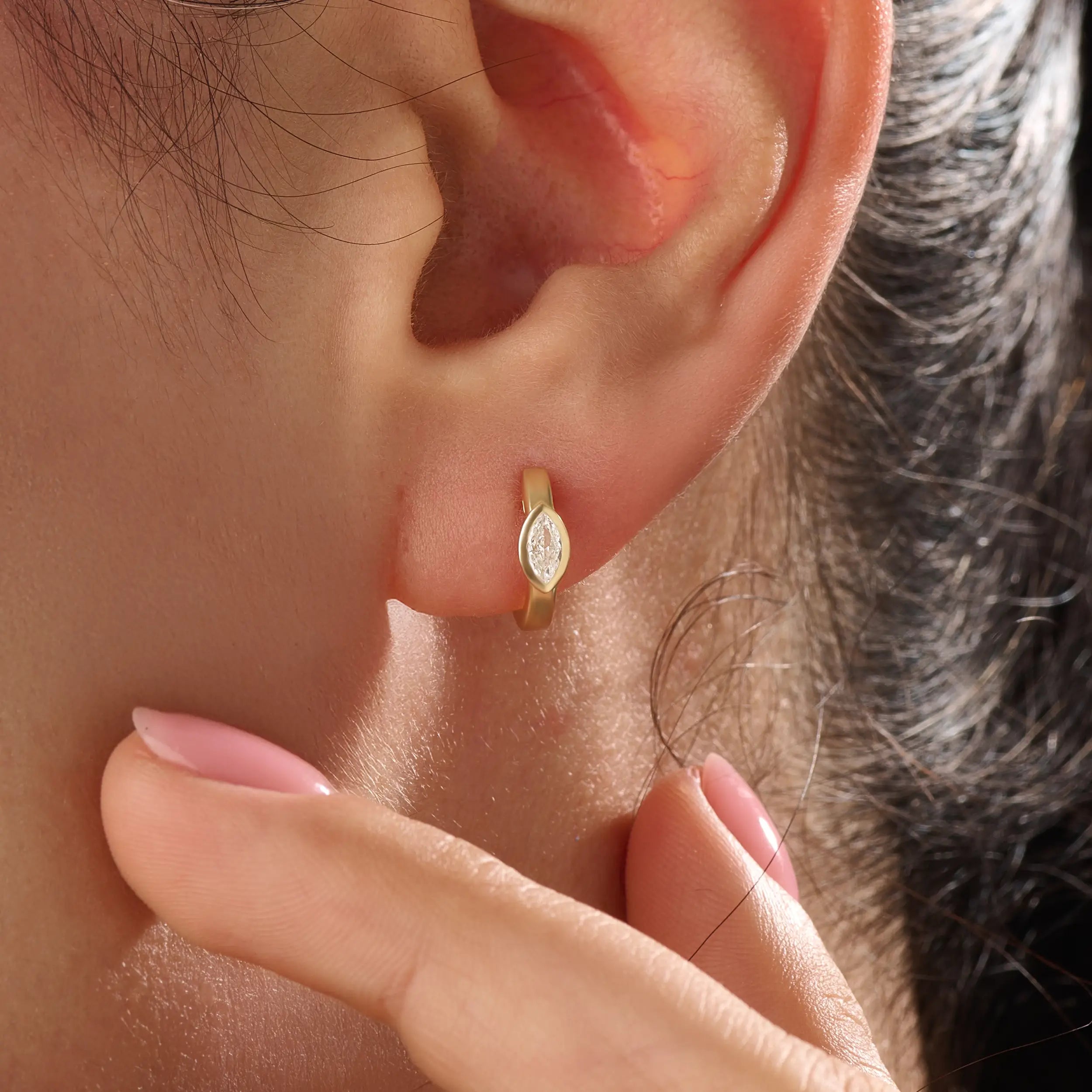 Model wearing 14k gold vermeil marquise bezel hoop earrings, displaying their refined sparkle and sculptural elegance — perfect for everyday luxury.
