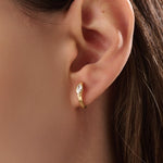 Model wearing 14k gold vermeil marquise bezel hoop earrings, displaying their refined sparkle and sculptural elegance — perfect for everyday luxury.
