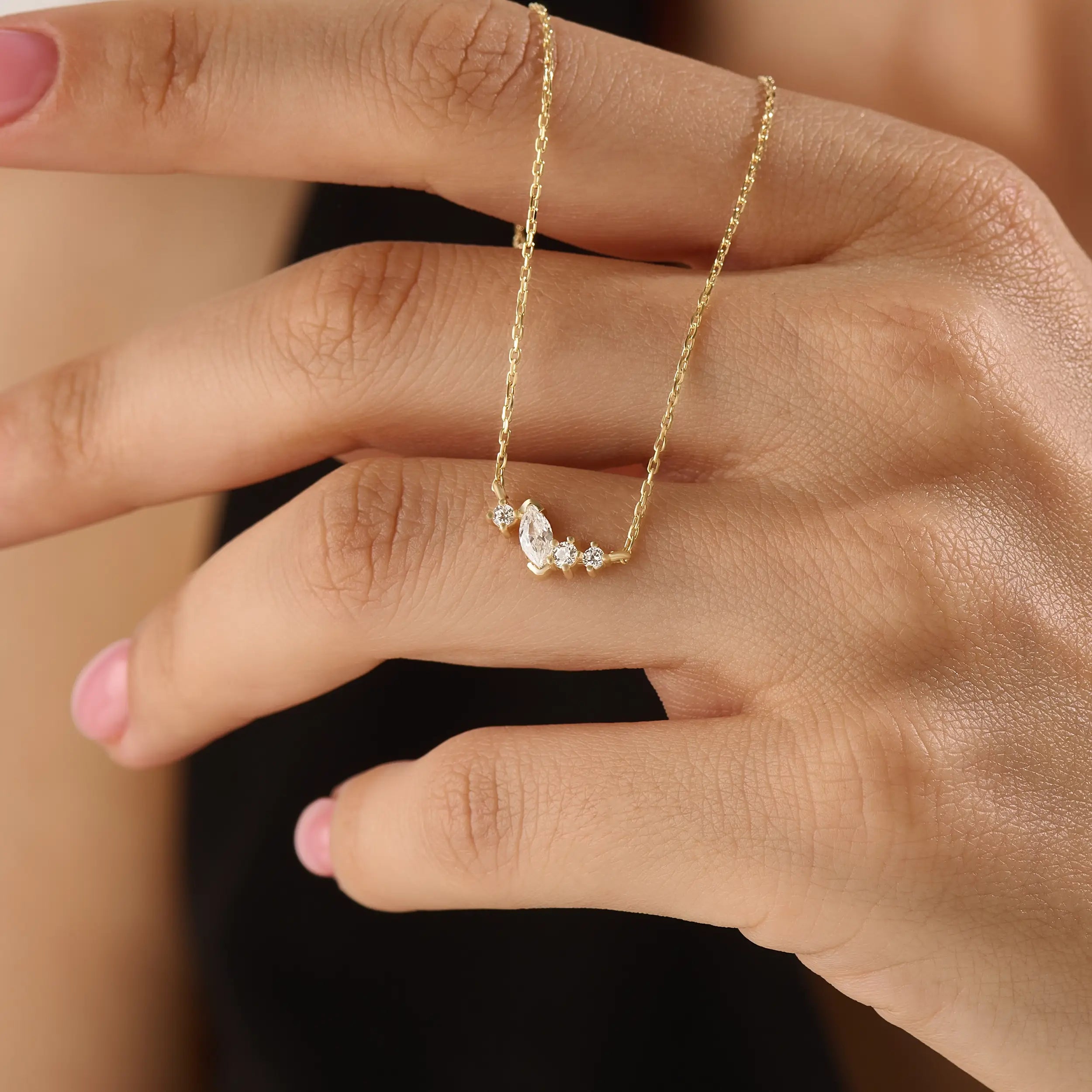 Model wearing a 14k gold vermeil mixed cut necklace featuring a cluster of marquise and round cubic zirconia stones, radiating delicate elegance and everyday glamour.
