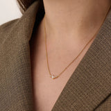 Model wearing a 14k gold vermeil mixed cut necklace featuring a cluster of marquise and round cubic zirconia stones, radiating delicate elegance and everyday glamour.
