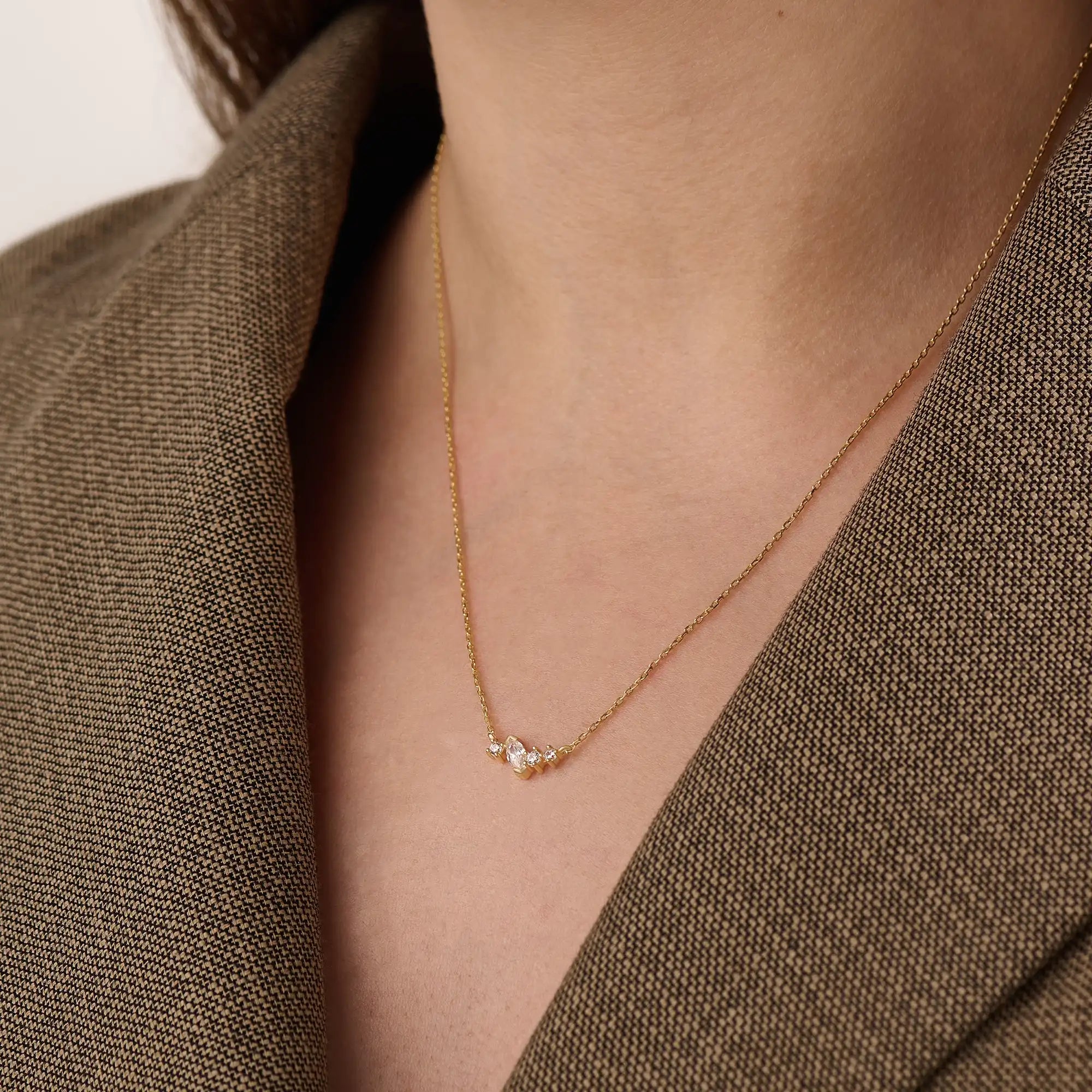 Model wearing a 14k gold vermeil mixed cut necklace featuring a cluster of marquise and round cubic zirconia stones, radiating delicate elegance and everyday glamour.

