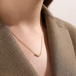 Model wearing a 14k gold vermeil mixed cut necklace featuring a cluster of marquise and round cubic zirconia stones, radiating delicate elegance and everyday glamour.
