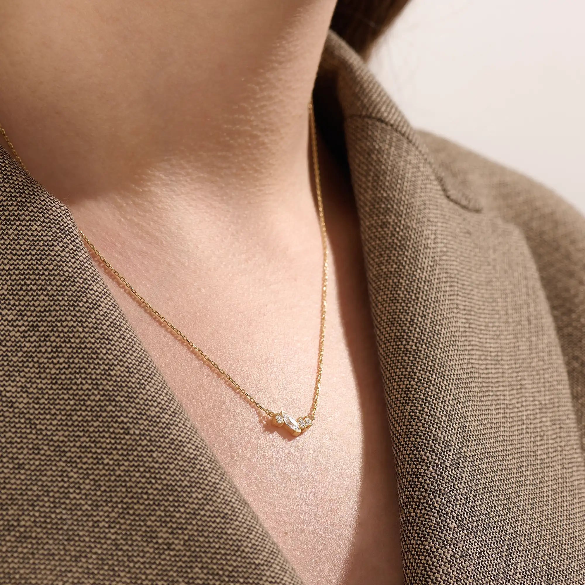 Model wearing a 14k gold vermeil mixed cut necklace featuring a cluster of marquise and round cubic zirconia stones, radiating delicate elegance and everyday glamour.
