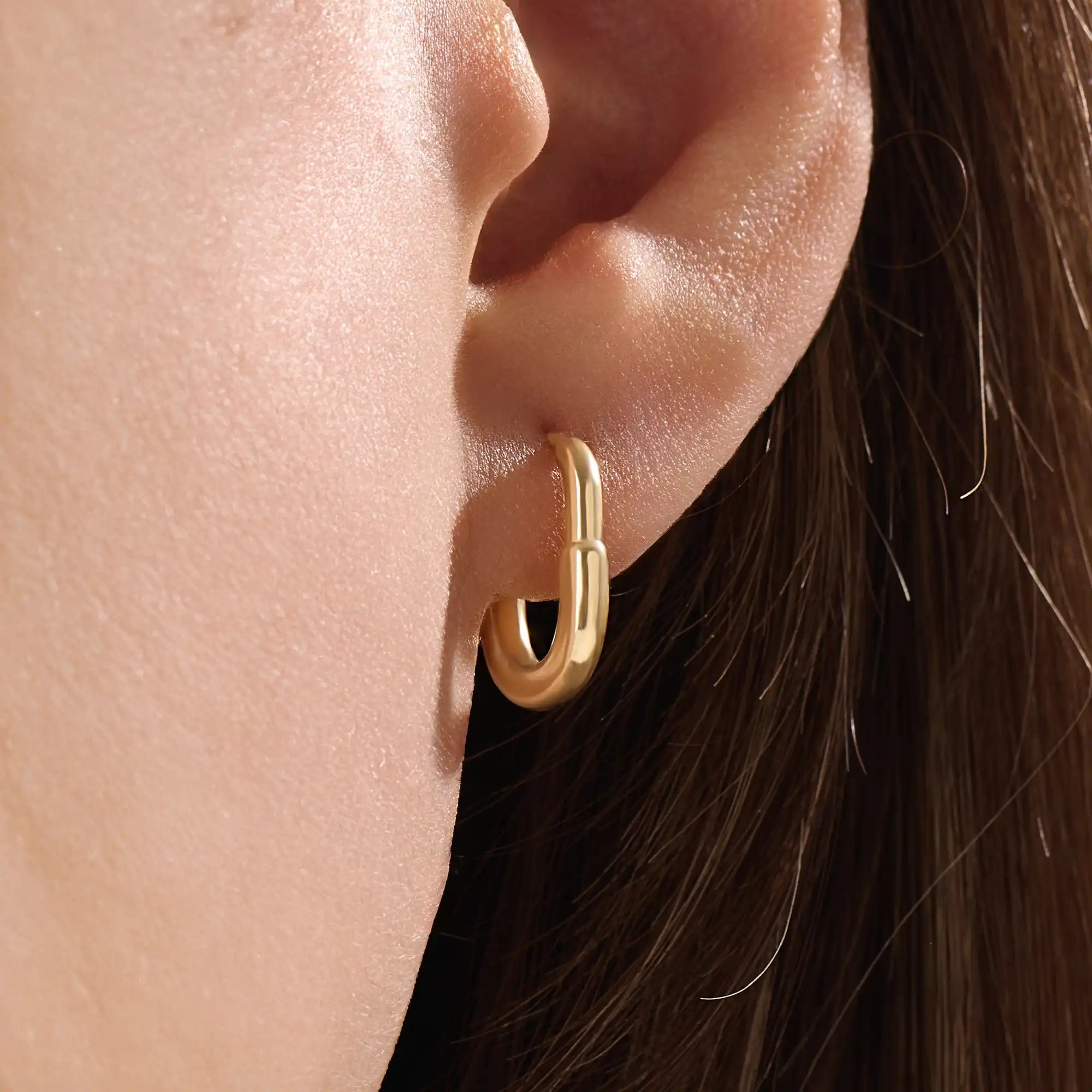 Model wearing 14k gold vermeil oval hoop earrings that combine timeless elegance with a modern oval shape for a polished, statement look.
