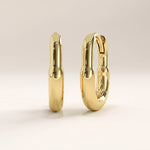 Side view of 14k gold vermeil oval hoop earrings showcasing the smooth curvature and secure hinged clasp for a refined and minimalist appeal.
