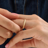 Model wearing a 14k gold vermeil patterned band ring with a shimmering diamond-like texture, reflecting light beautifully for a chic statement look.
