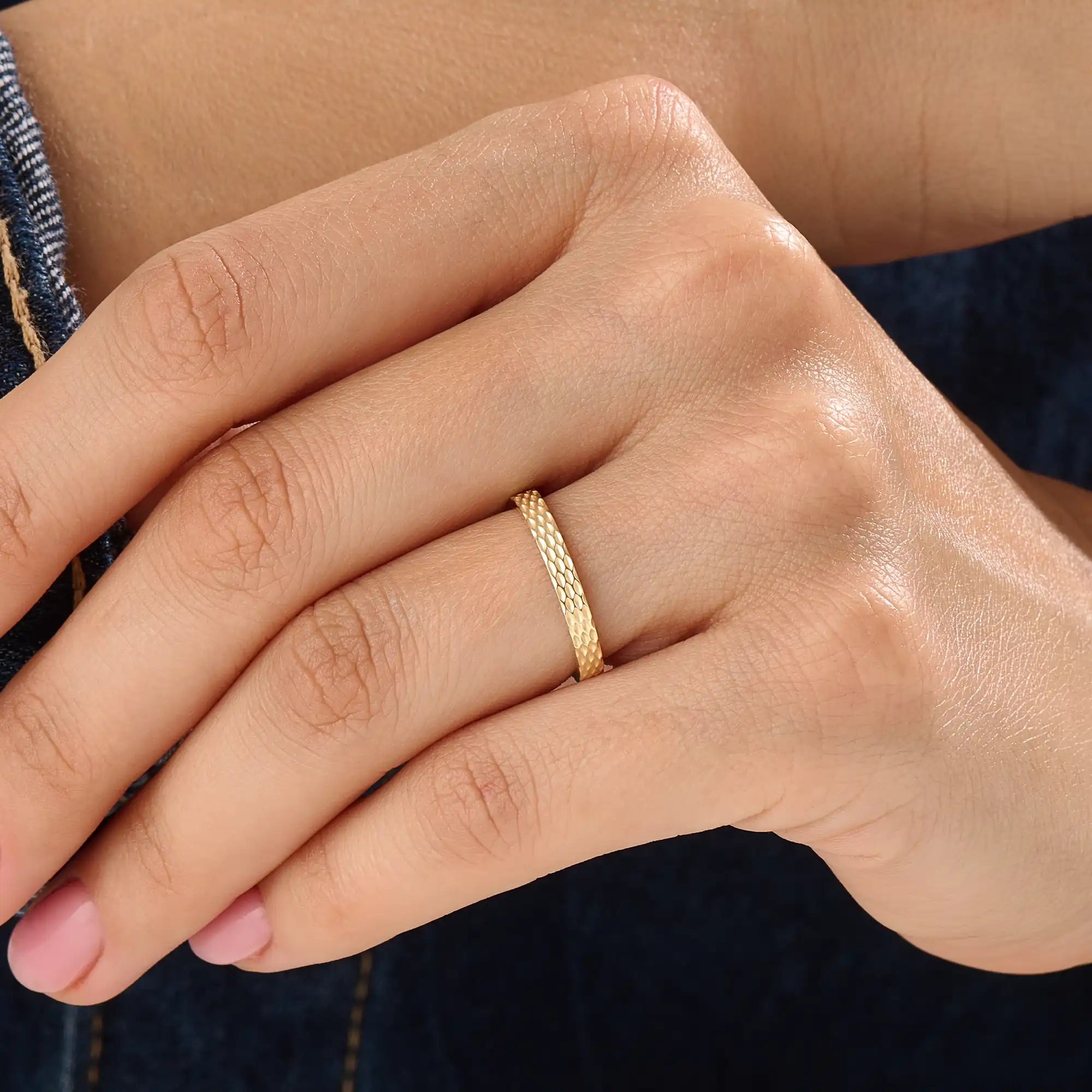 Model wearing a 14k gold vermeil patterned band ring with a shimmering diamond-like texture, reflecting light beautifully for a chic statement look.
