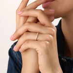 Model wearing a 14k gold vermeil patterned band ring with a shimmering diamond-like texture, reflecting light beautifully for a chic statement look.
