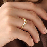 Model wearing a 14k gold vermeil pear curve ring with an elegant sweeping design and a single pear-cut stone for a graceful, luminous finish.
