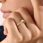 Model wearing a 14k gold vermeil pear curve ring with an elegant sweeping design and a single pear-cut stone for a graceful, luminous finish.
