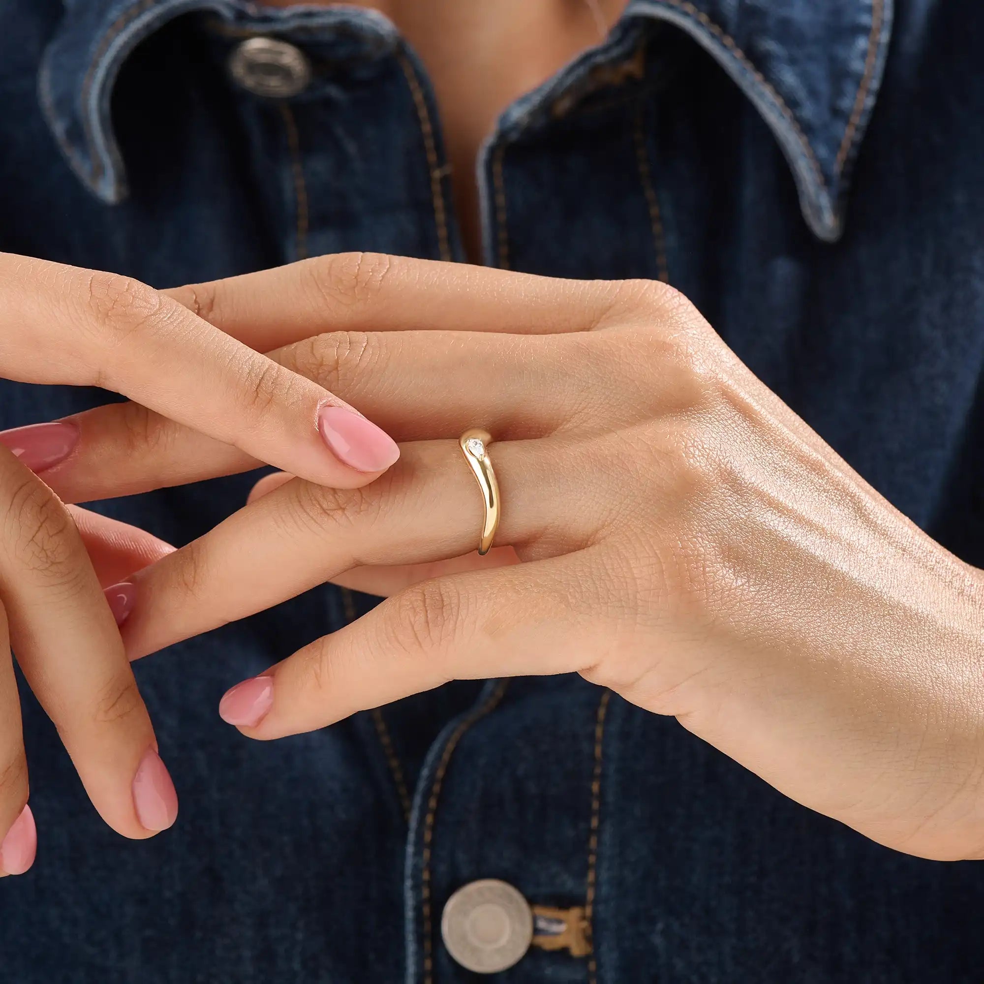 Model wearing a 14k gold vermeil pear curve ring with an elegant sweeping design and a single pear-cut stone for a graceful, luminous finish.
