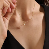 Model wearing a 14k gold vermeil princess solitaire necklace featuring a radiant square-cut cubic zirconia pendant for an understated yet sophisticated sparkle.
