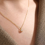 Model wearing a 14k gold vermeil princess solitaire necklace featuring a radiant square-cut cubic zirconia pendant for an understated yet sophisticated sparkle.
