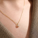 Model wearing a 14k gold vermeil princess solitaire necklace featuring a radiant square-cut cubic zirconia pendant for an understated yet sophisticated sparkle.
