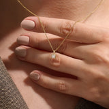 Model wearing a 14k gold vermeil princess solitaire necklace featuring a radiant square-cut cubic zirconia pendant for an understated yet sophisticated sparkle.
