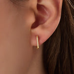 Model wearing 14k gold vermeil rectangle hoop earrings that highlight their clean, sculptural lines and lustrous golden sheen — ideal for modern everyday style.
