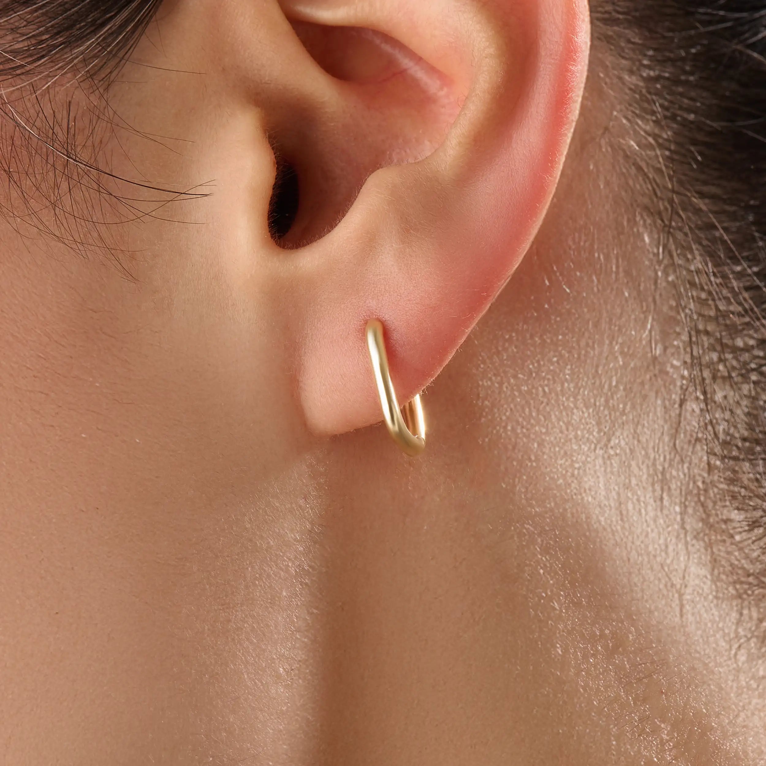 Model wearing 14k gold vermeil rectangle hoop earrings that highlight their clean, sculptural lines and lustrous golden sheen — ideal for modern everyday style.
