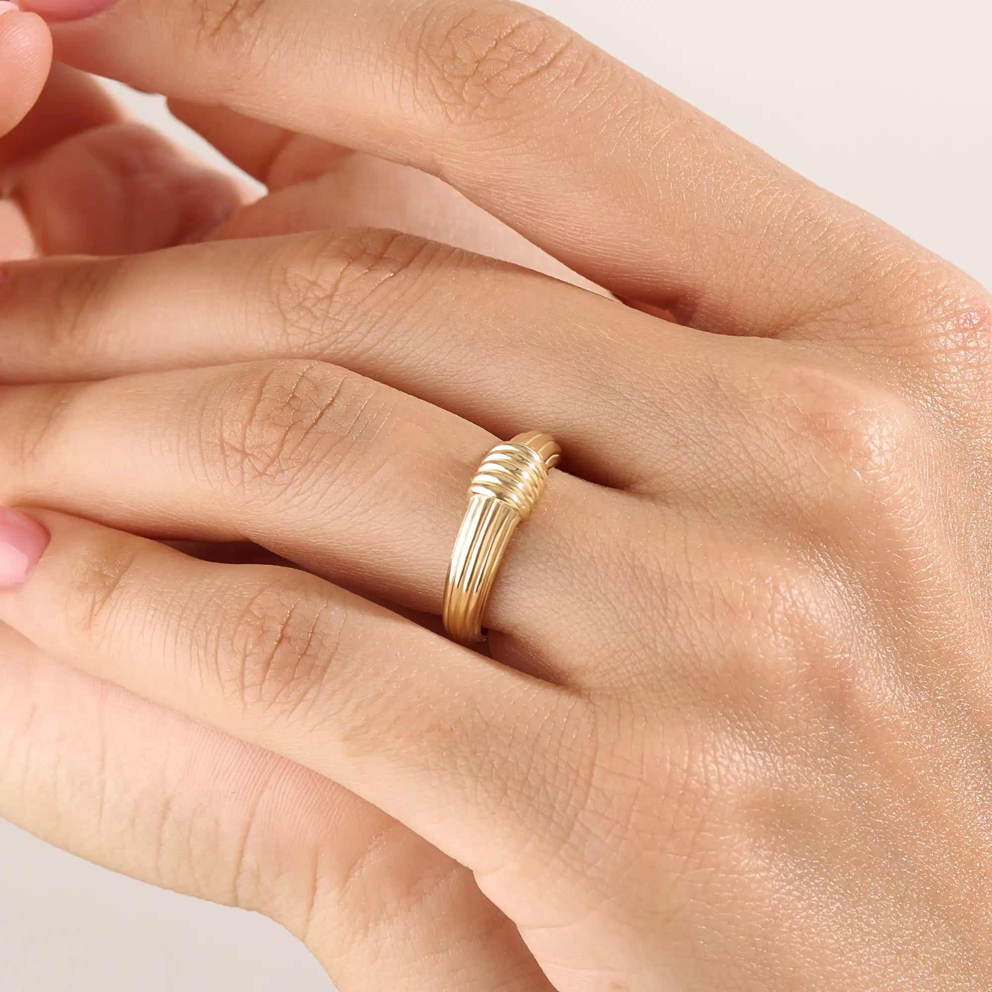 Model wearing a 14k gold vermeil ribbed dome ring showcasing its modern grooved design and bold polished shine for a chic everyday look.
