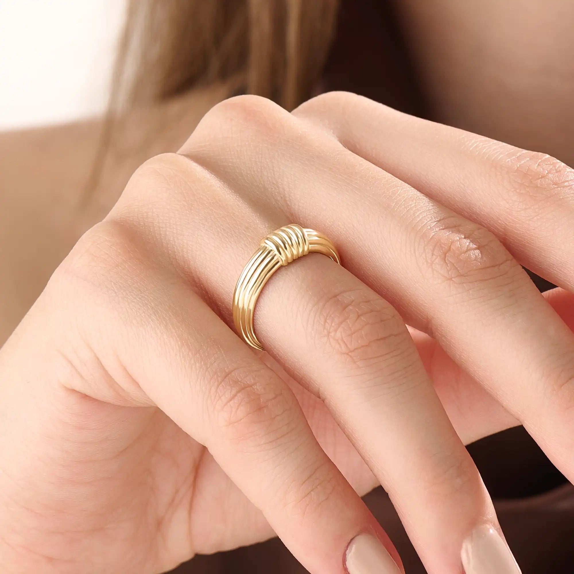 Model wearing a 14k gold vermeil ribbed dome ring showcasing its modern grooved design and bold polished shine for a chic everyday look.
