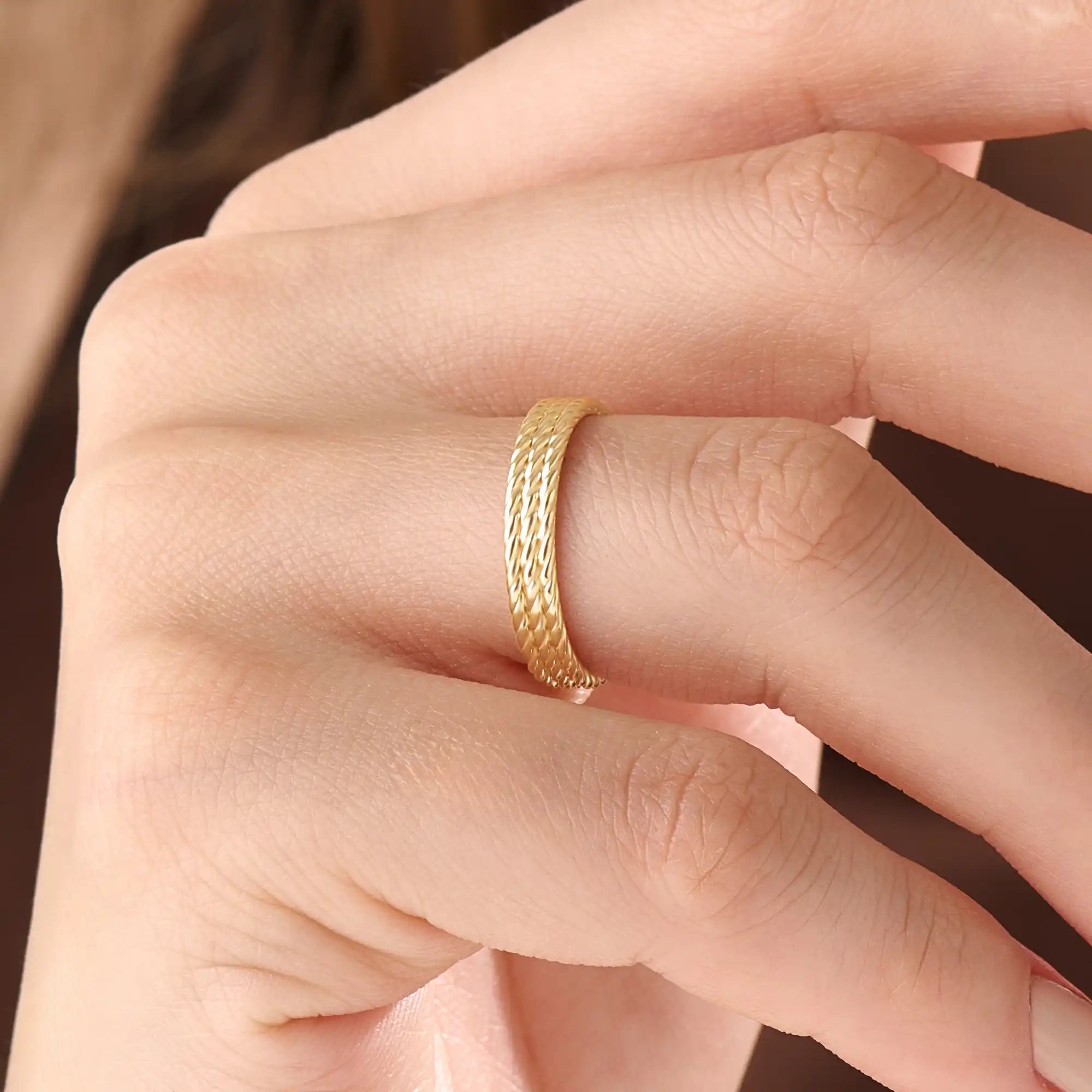 Model wearing a 14k gold vermeil rope band ring, displaying its elegant twisted design and radiant gold sheen for a sophisticated everyday look.
