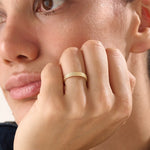 Model wearing a 14k gold vermeil rope band ring, displaying its elegant twisted design and radiant gold sheen for a sophisticated everyday look.
