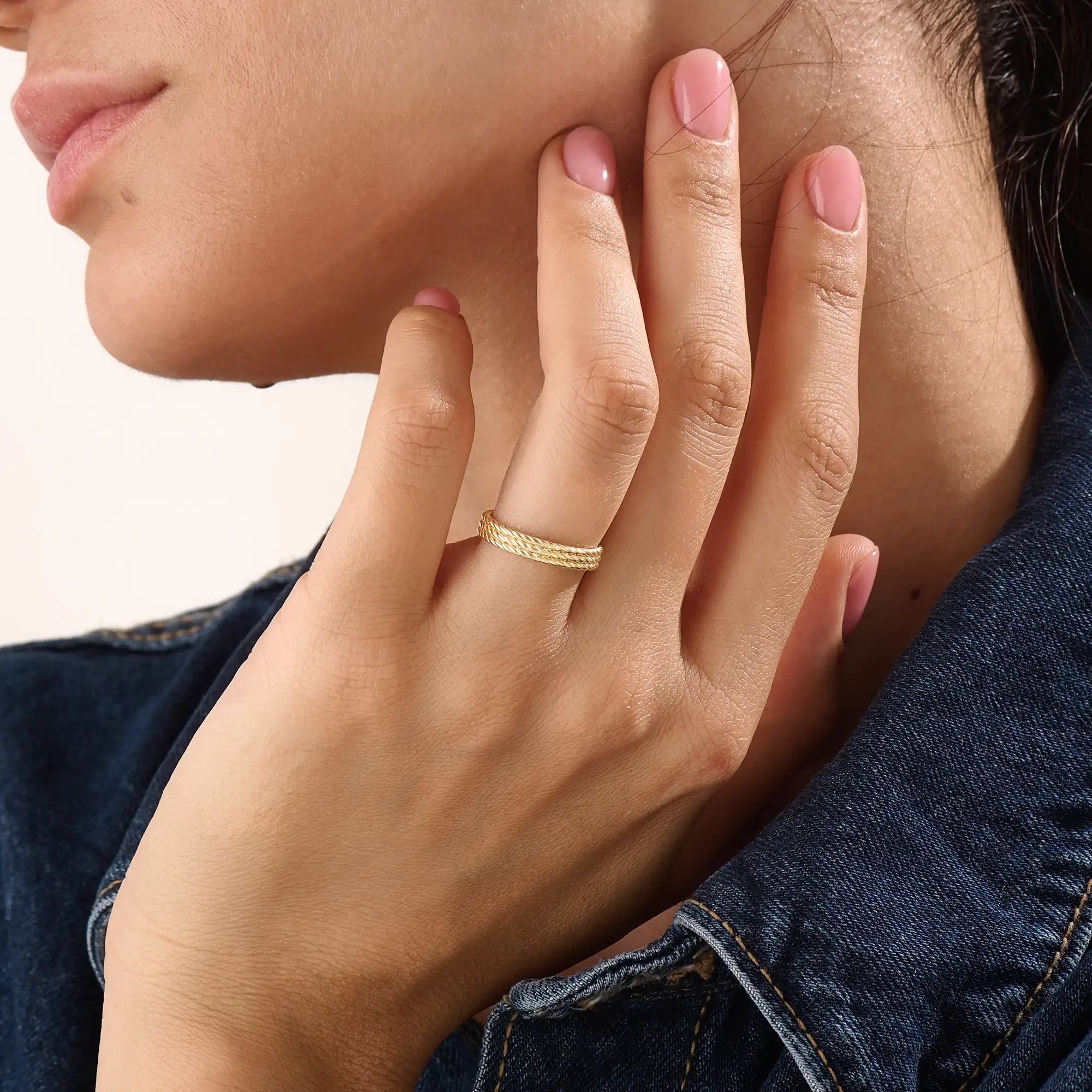 Model wearing a 14k gold vermeil rope band ring, displaying its elegant twisted design and radiant gold sheen for a sophisticated everyday look.
