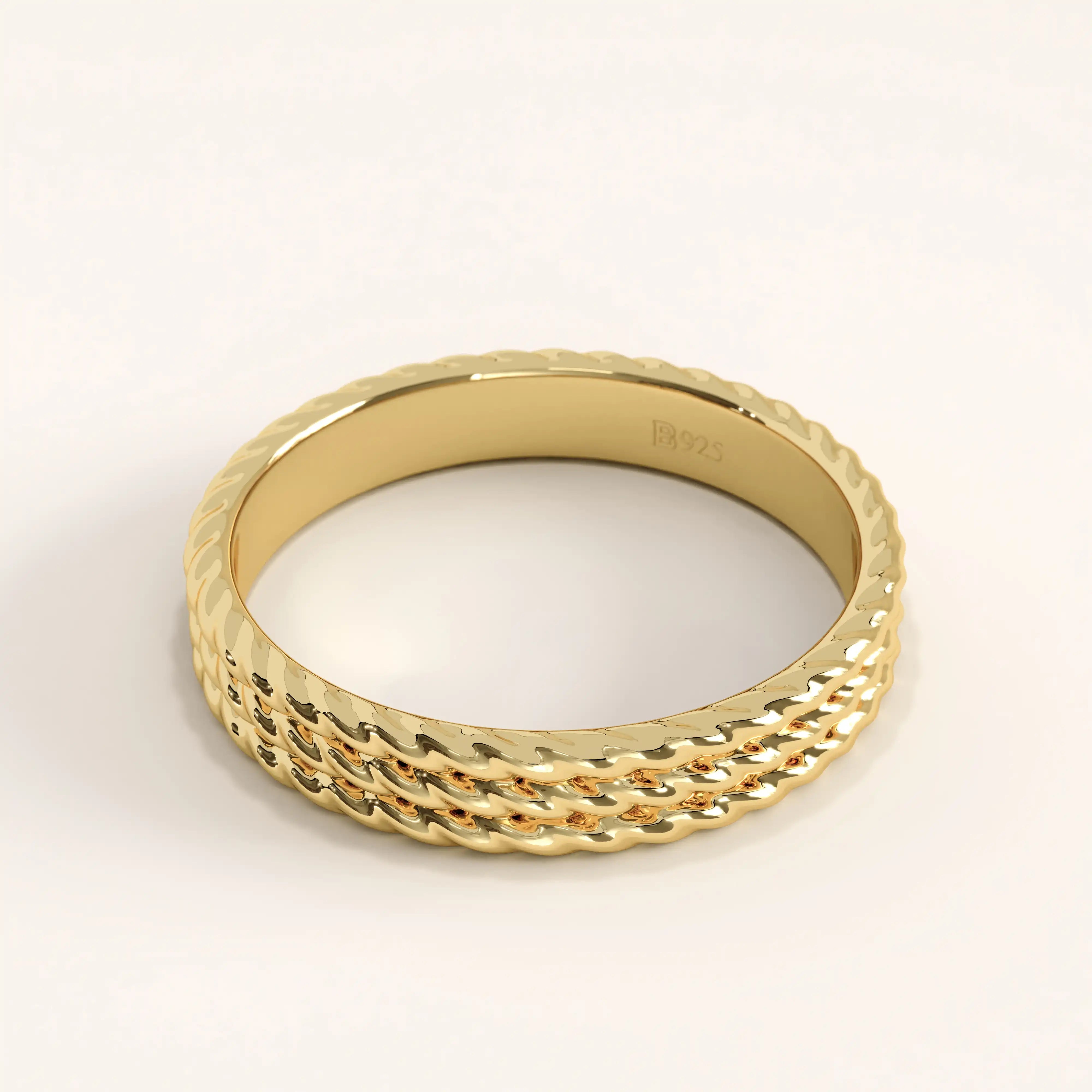 Side angle of 14k gold vermeil rope band ring showcasing its intricate triple-rope texture and reflective polished surface.
