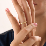 Model wearing a 14k gold vermeil simple band ring, highlighting its slim layered design and radiant gold sheen for a refined modern look.

