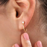 Model wearing 14k gold vermeil solo hoop earrings showcasing a single sparkling cubic zirconia, perfect for an understated yet sophisticated everyday look.
